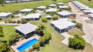 A residential area with multiple single-story houses, a swimming pool, and a well-maintained lawn. - Casa Nostra Motel (Parkhurst)