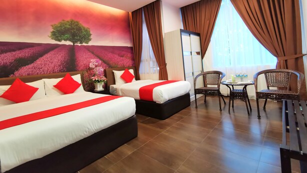 A hotel room with two beds, a dining table, chairs, a vase with flowers, and a large window with curtains. - Palazzo Hotel Kulai (Kulai)