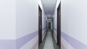 A long, narrow hallway with doors on both sides, leading to a room at the end. - Palazzo Hotel Kulai (Kulai)