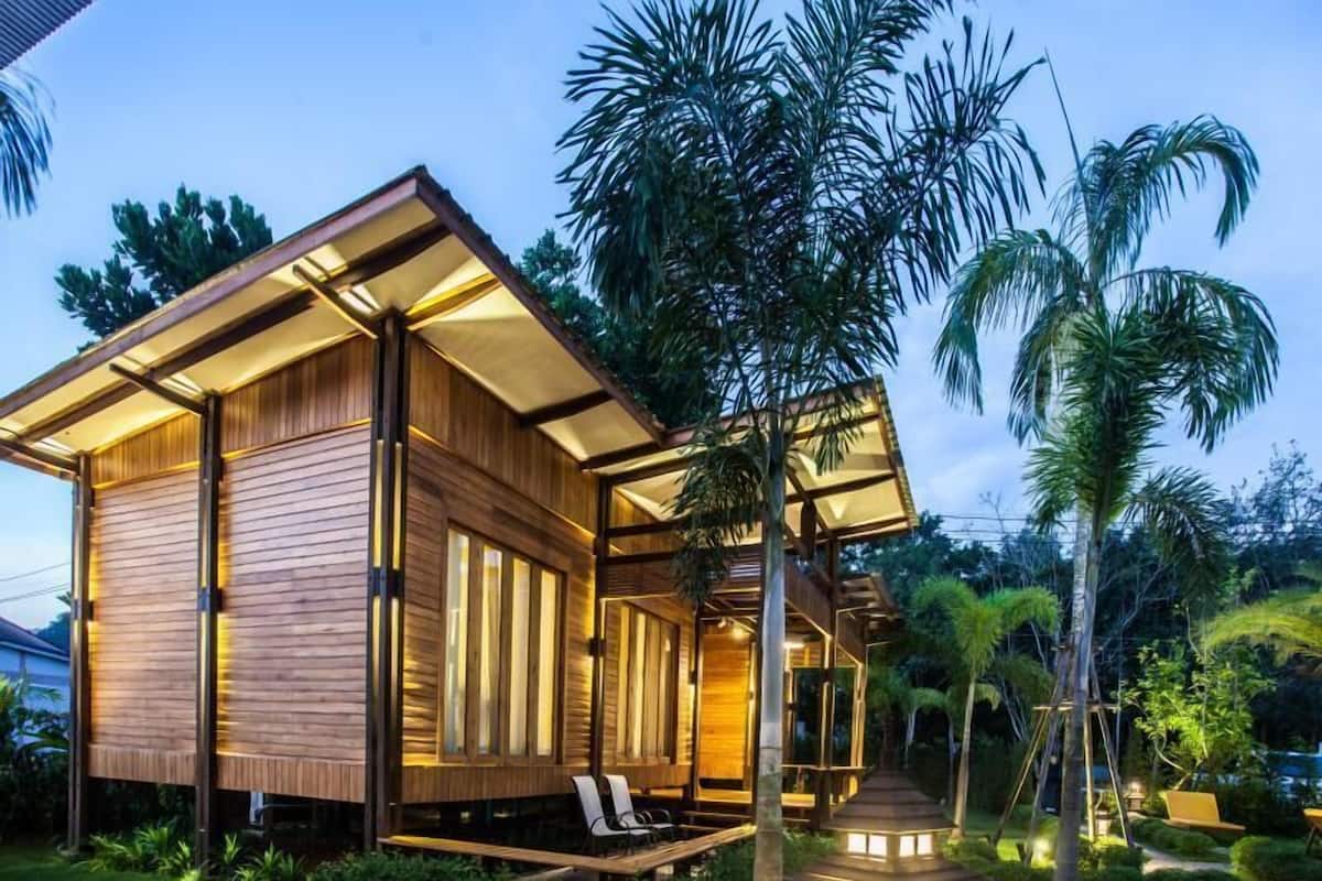 Una casa moderna de madera con porche cubierto y jardín.