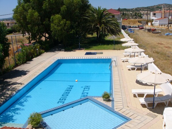 室外游泳池，池畔遮阳伞，日光浴躺椅