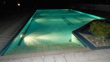 Alberca al aire libre, sombrillas en la alberca y camastros