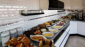 A kitchen with a long counter filled with various food items and utensils. - Cappadocia Symbol Hotel (Nevsehir)