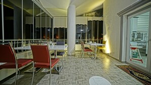 A restaurant with red chairs, white tables, and a patterned floor. - Cappadocia Symbol Hotel (Nevsehir)