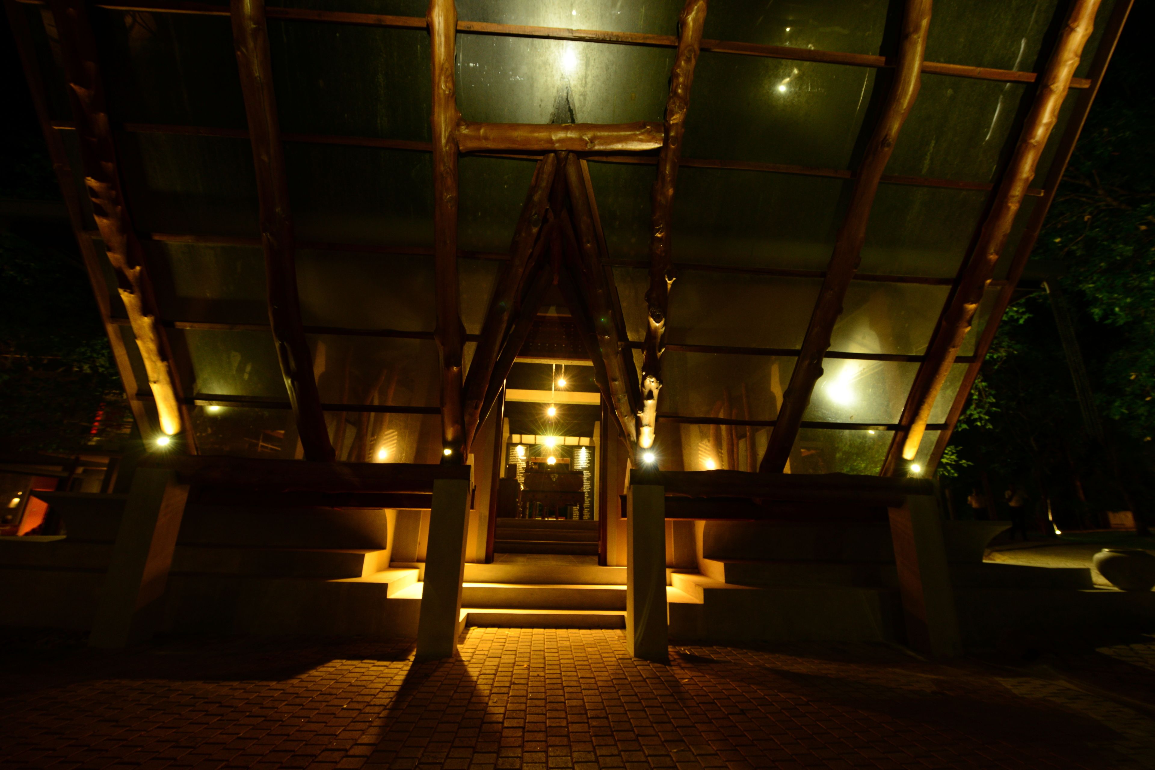 A staircase leading to a glass-walled entrance of a building at night.