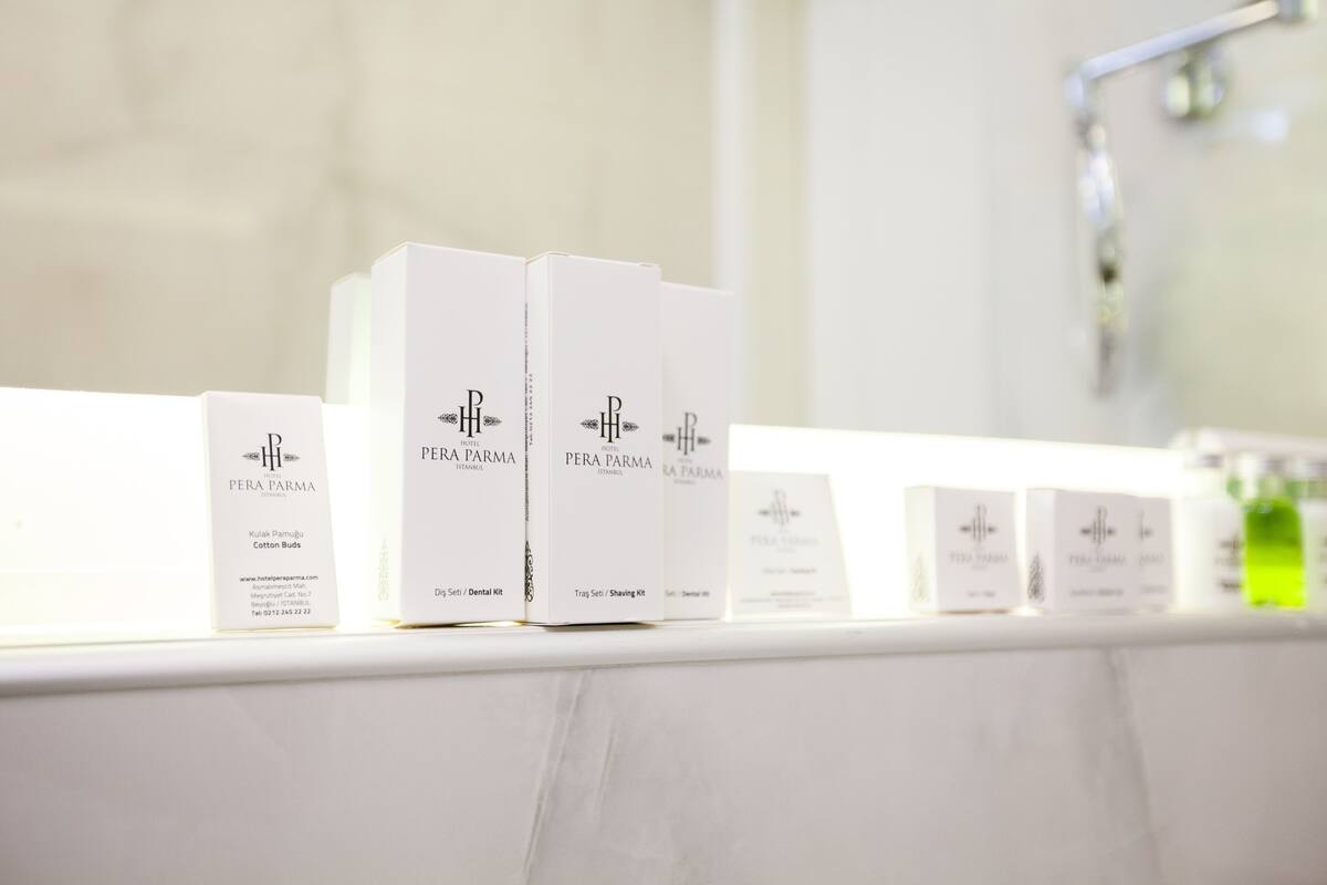 Un baño con encimeras de mármol blanco que exhiben diversos productos Pera Parma.