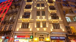 A multi-story building with illuminated signage for 'eczone perla' and 'caffè del sarto'. - Hotel Pera Parma (Istanbul)