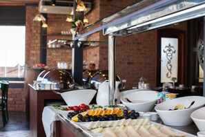 A buffet with various food items and a brick wall in the background. - Hotel Pera Parma (Istanbul)