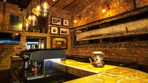 A bar area with a brick wall, hanging light fixtures, and a coffee machine. - Hotel Pera Parma (Istanbul)