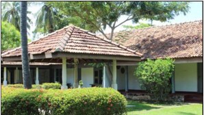 A traditional building with a tiled roof, a covered porch, and well-maintained greenery. - City Hub Lagoon (Negombo)