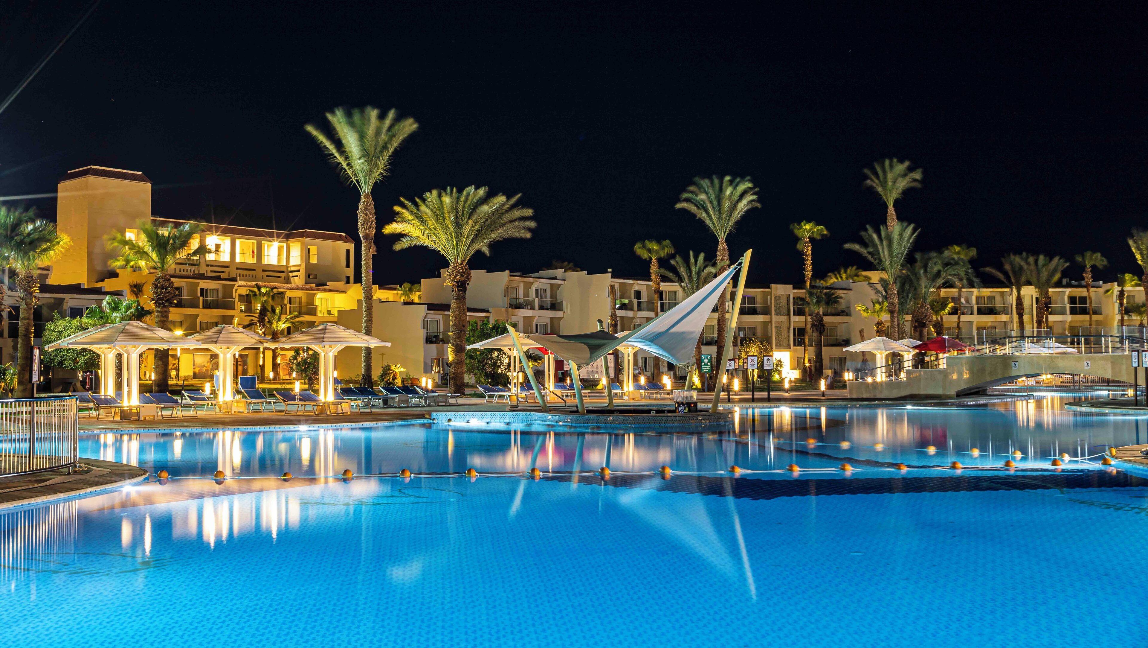 Una piscina al aire libre, sombrillas, tumbonas