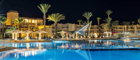 Una piscina al aire libre, sombrillas, tumbonas