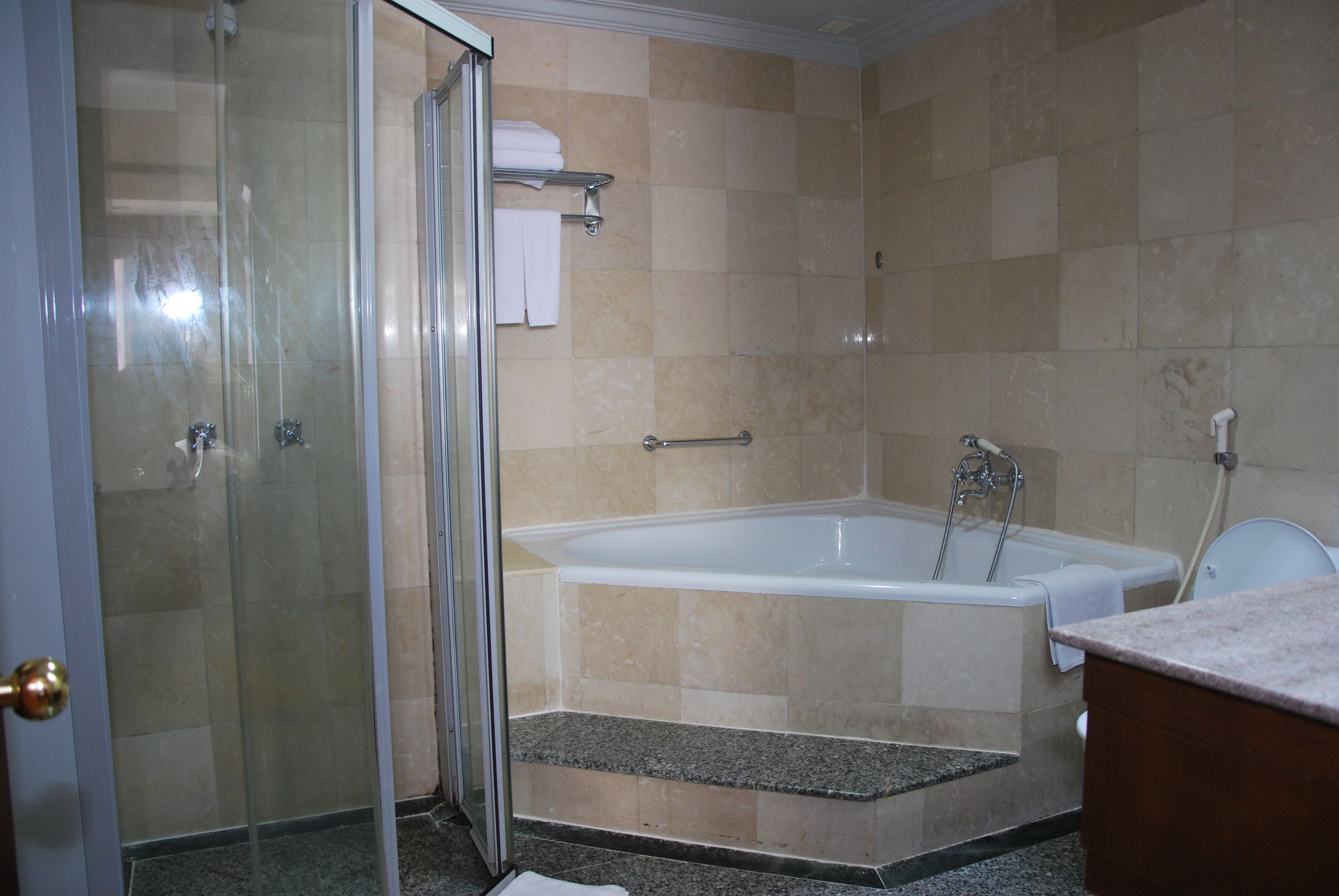 A bathroom with a glass shower enclosure, a bathtub, and a vanity with a sink.