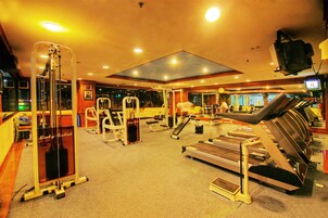 Une salle de sport équipée de divers appareils d’exercice, notamment des tapis de course et des appareils de musculation.