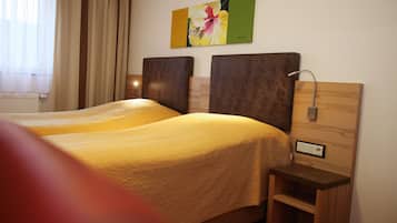 Ein Hotelzimmer mit zwei Betten, einem Nachttisch mit Lampe und einem Bild an der Wand.