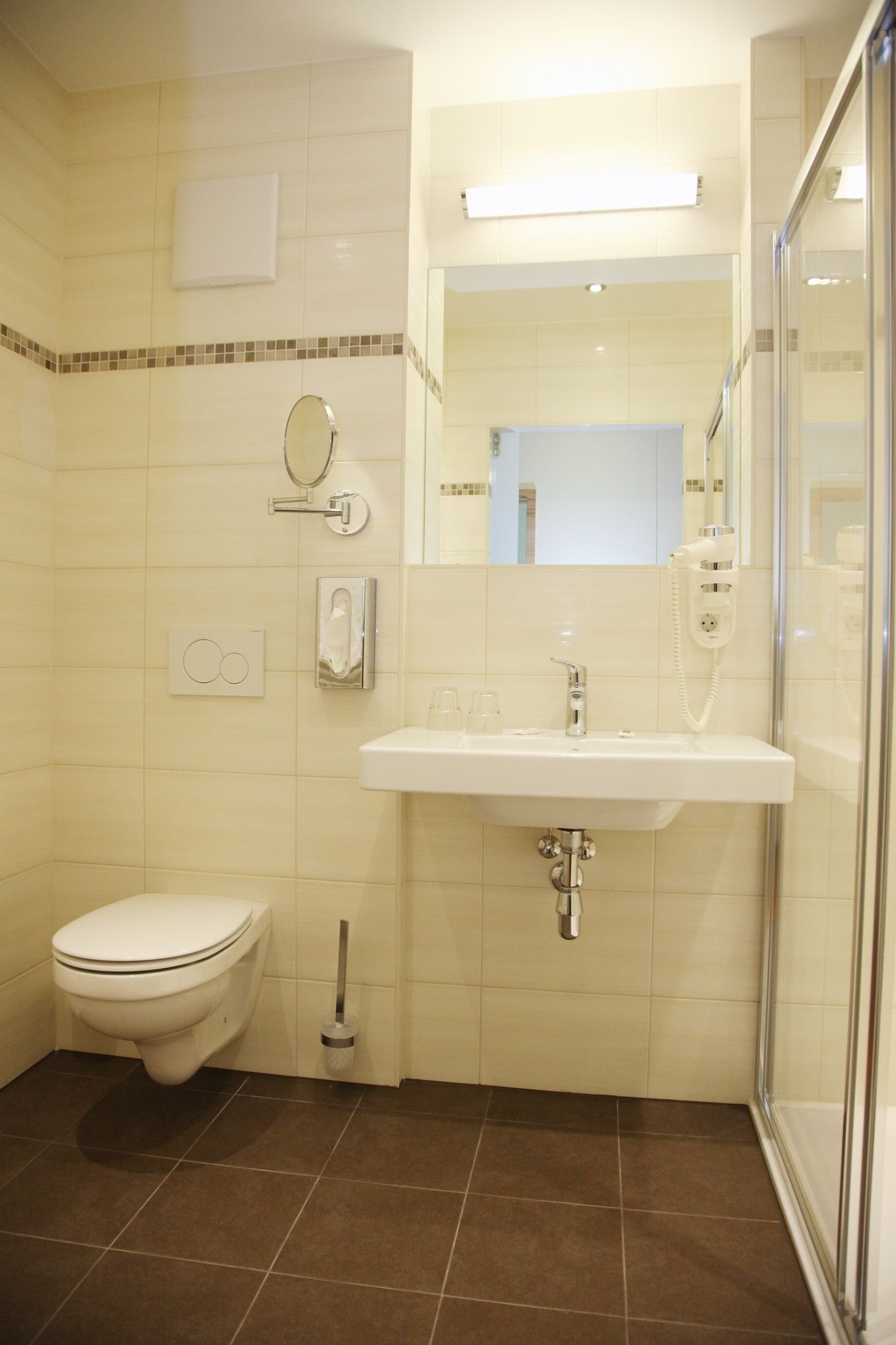 Un baño con inodoro, lavabo, espejo y ducha.