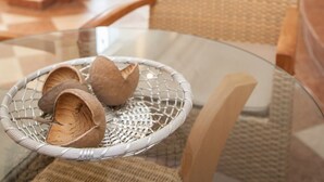 A wicker chair and a glass table with a basket of shoes. - Tinschert Hotel-Restaurant-Partyservice (Schwertberg)