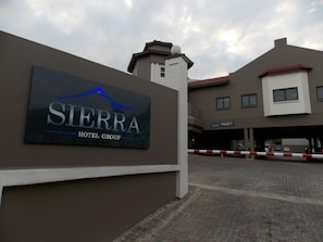 Entrada de un hotel con un cartel que dice "Sierra Hotel Group".