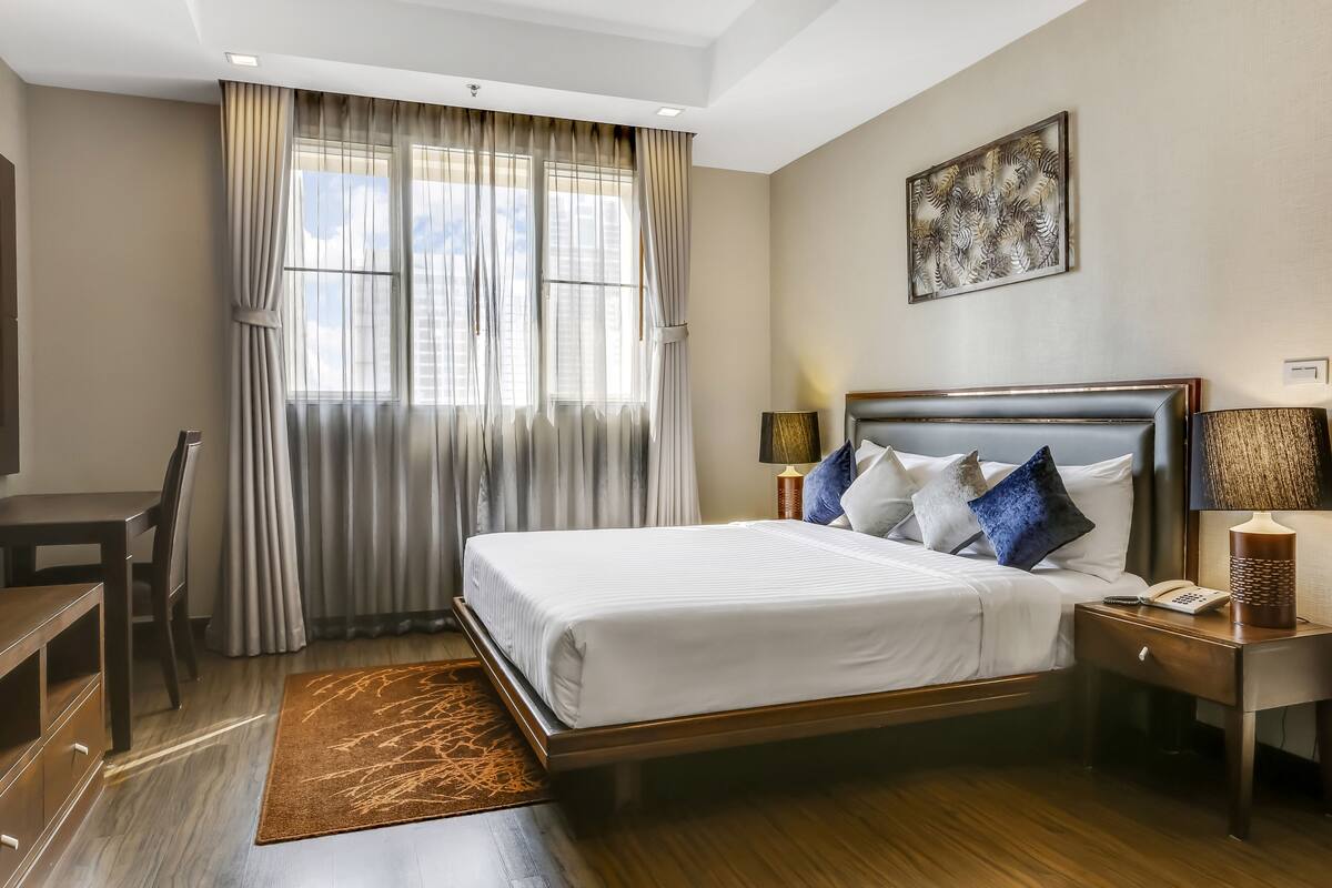 Een hotelkamer met een groot bed, een bureau en een stoel.