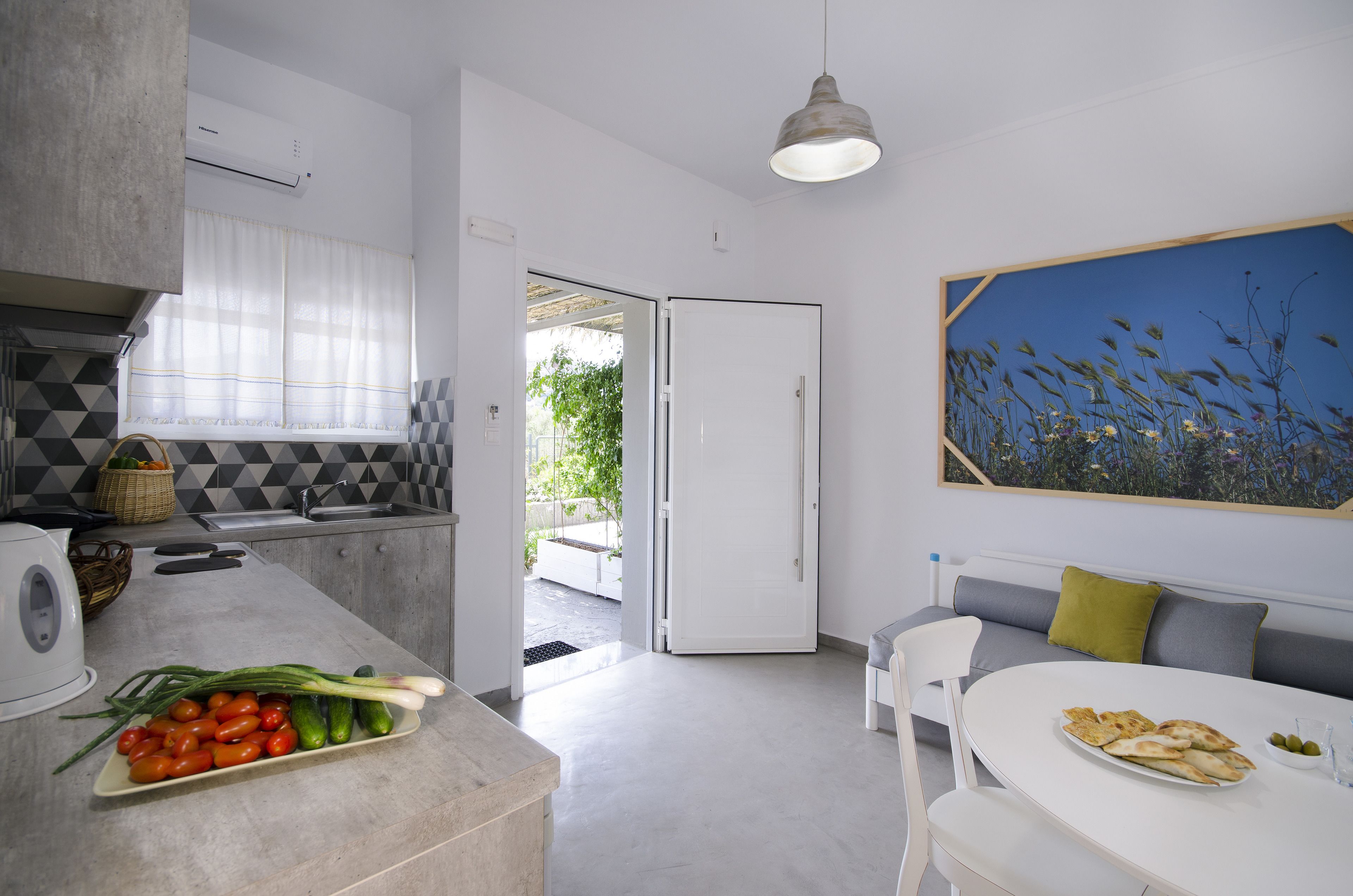 Una cocina moderna con comedor, un sofá blanco y un cuadro de flores.