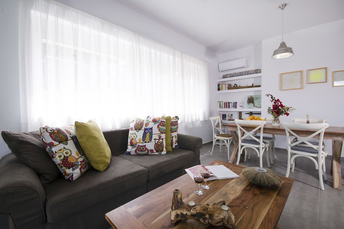 Una sala de estar moderna con sofá, mesa de centro y comedor.