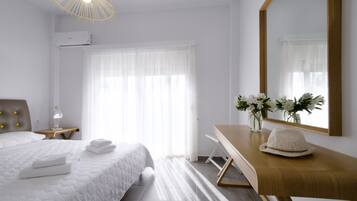 Un dormitorio moderno con cama, mesita de noche y escritorio con espejo.