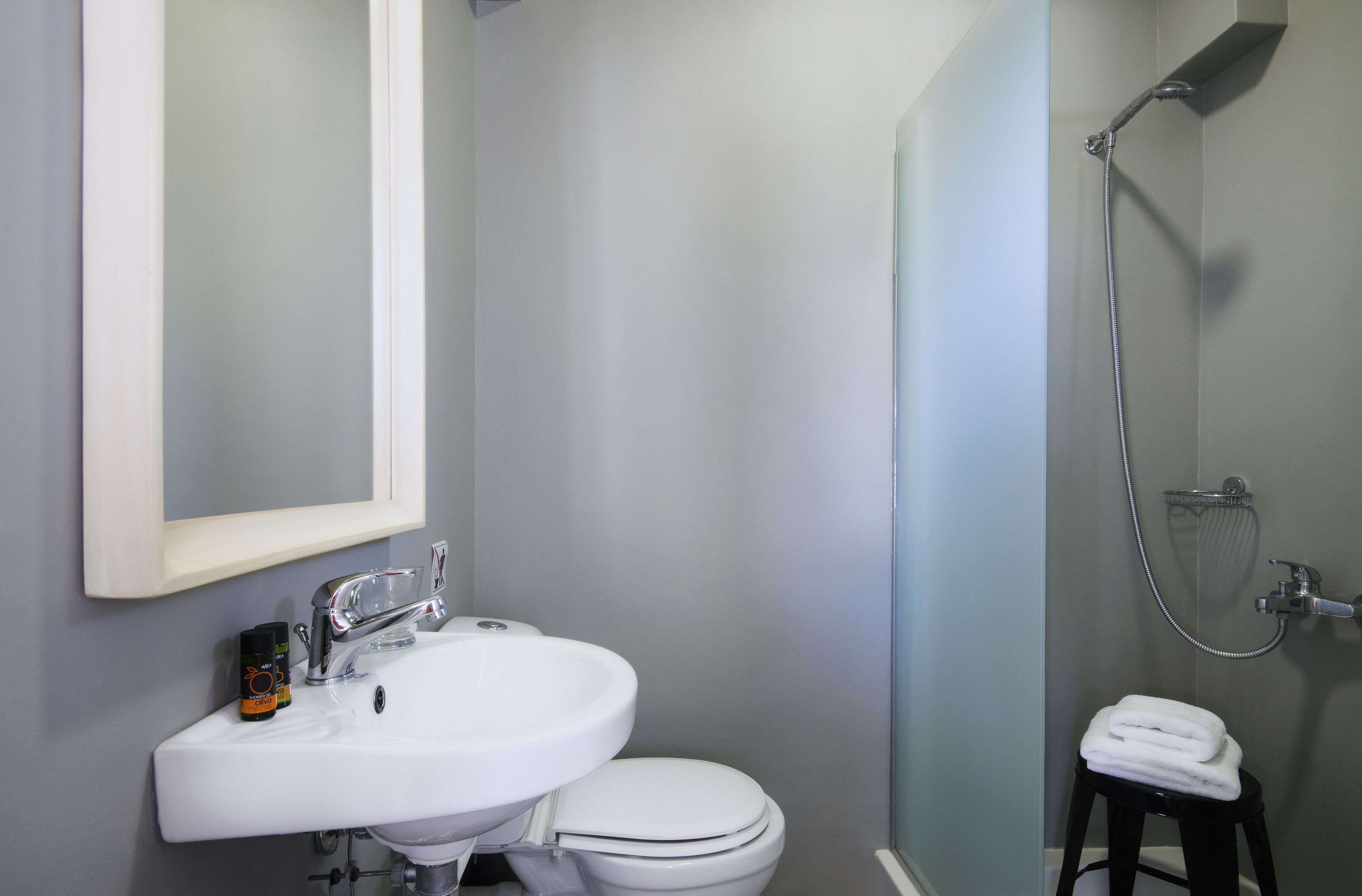 A bathroom with a white sink, toilet, and shower.