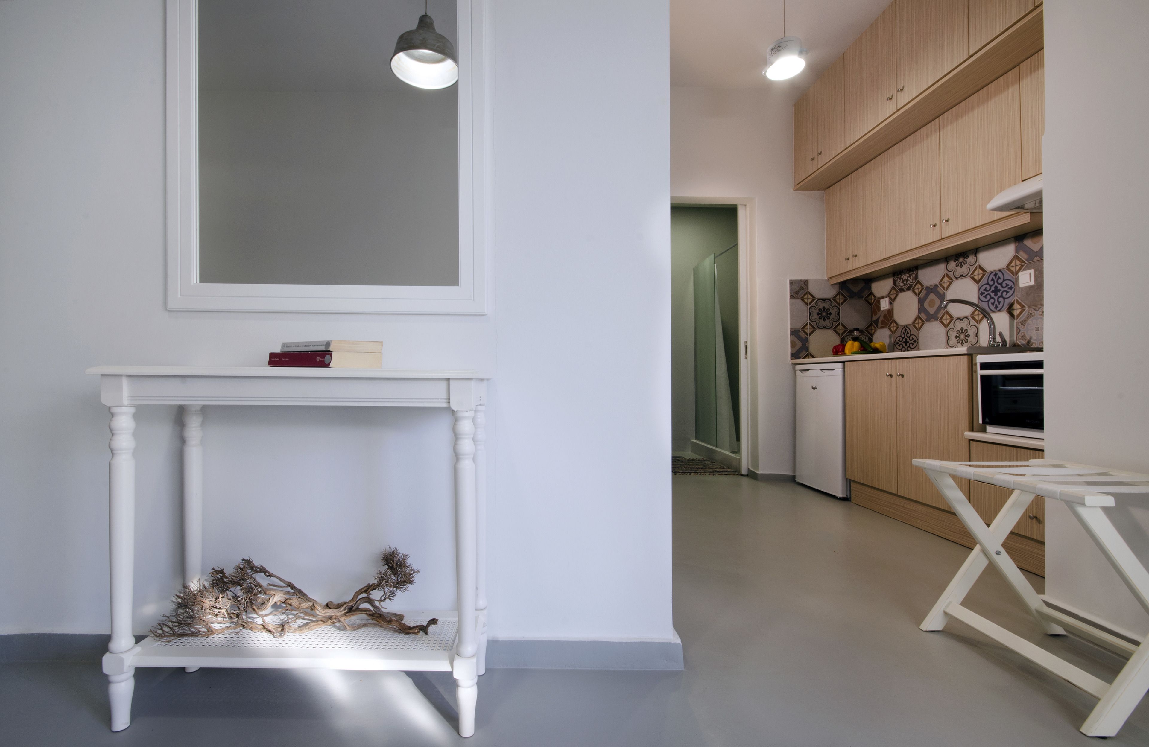 A modern kitchen with wooden cabinets, a white table, and a small dining area.