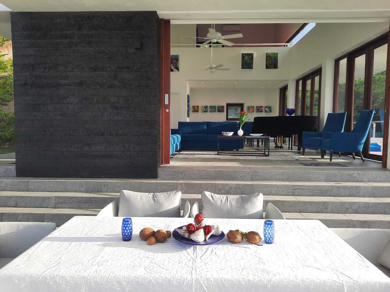 A dining area with a table set for two, featuring a fruit bowl and candles.