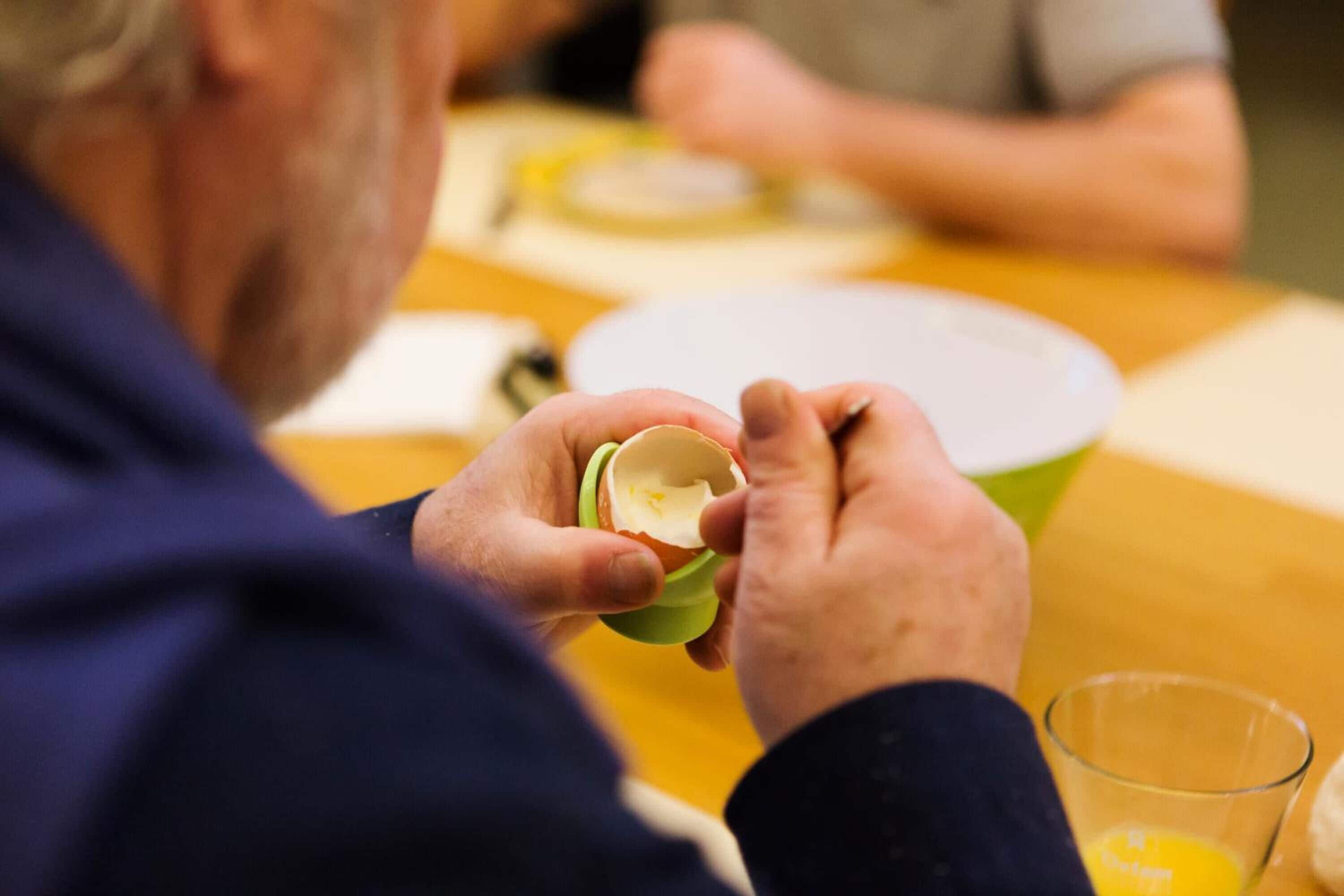 A person holding a green bowl with a white interior, possibly containing food or a drink.