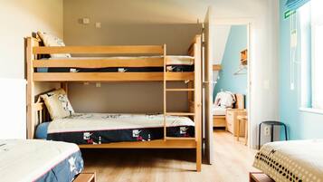 A bunk bed room with a ladder, a desk, and a chair.