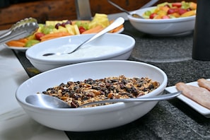 A buffet table with bowls of cereal and fruits. - The Coach House at Val du Charron (Wellington)