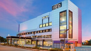 A modern hotel with a prominent 'HOTEL NEO' sign, large windows, and a well-lit entrance. - Hotel Neo Palma - Palangkaraya by ASTON (Palangkaraya)