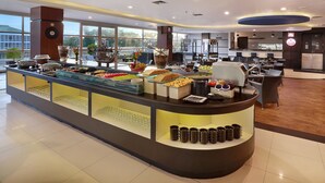 A modern hotel lobby with a buffet area featuring various food items and a coffee station. - Hotel Neo Palma - Palangkaraya by ASTON (Palangkaraya)