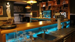 A bar area with a reception desk, a statue, and a blue-lit bar counter. - Rheinhotel Lilie (Boppard)