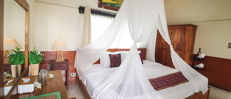 A bedroom with a four-poster bed, a wooden nightstand, a bedside table, and a mirror.