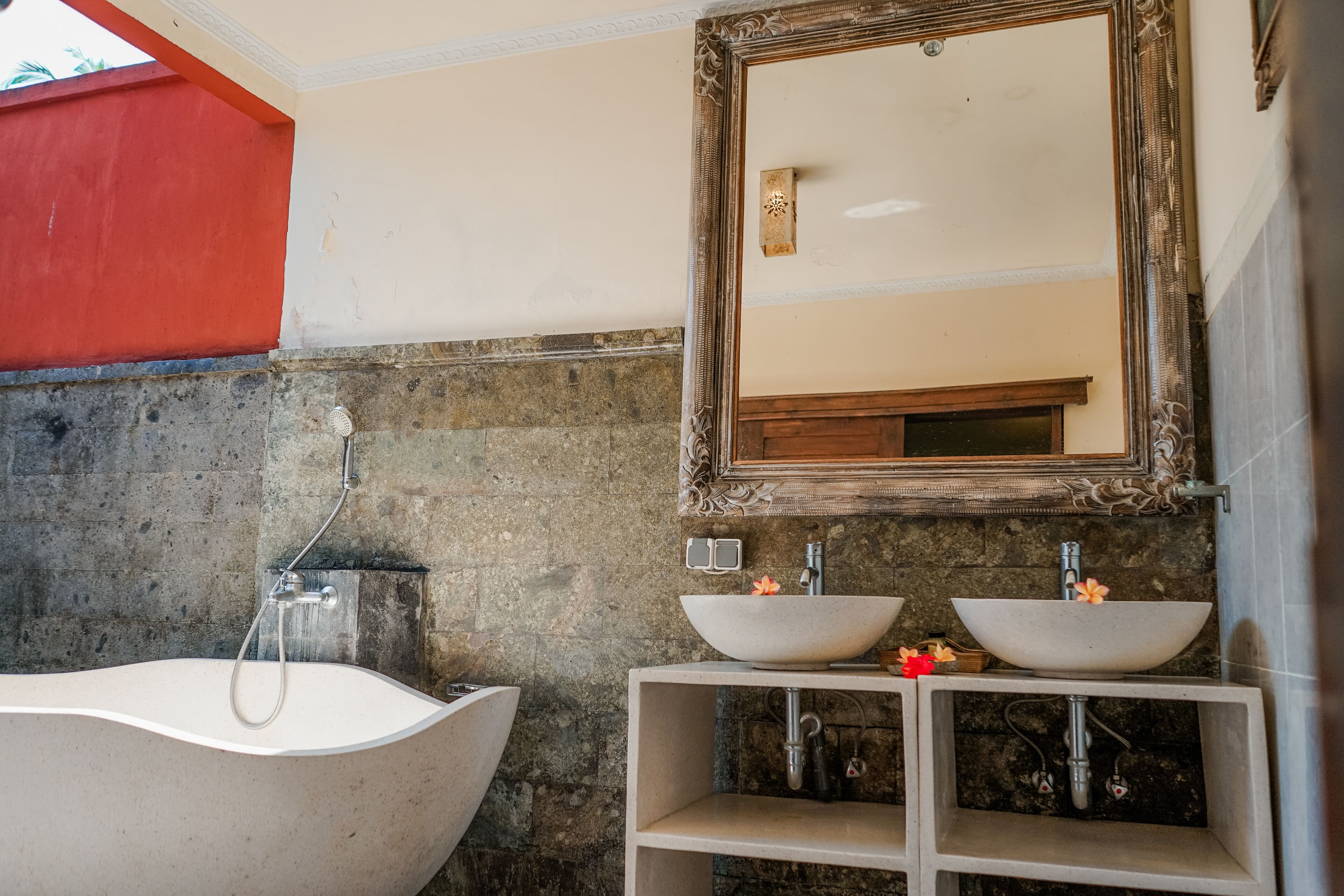 A bathroom with a freestanding bathtub, two sinks, and a large mirror.