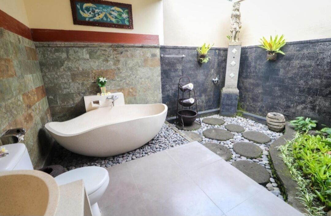A bathroom with a freestanding bathtub, a toilet, and a sink.