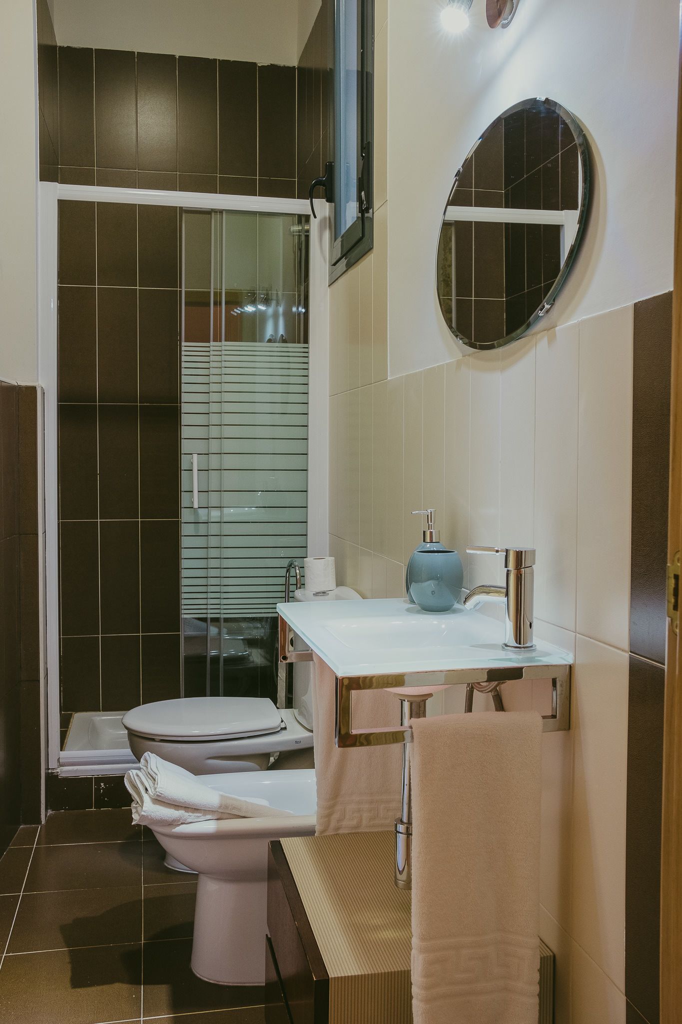 Een moderne badkamer met toilet, wastafel en douche.