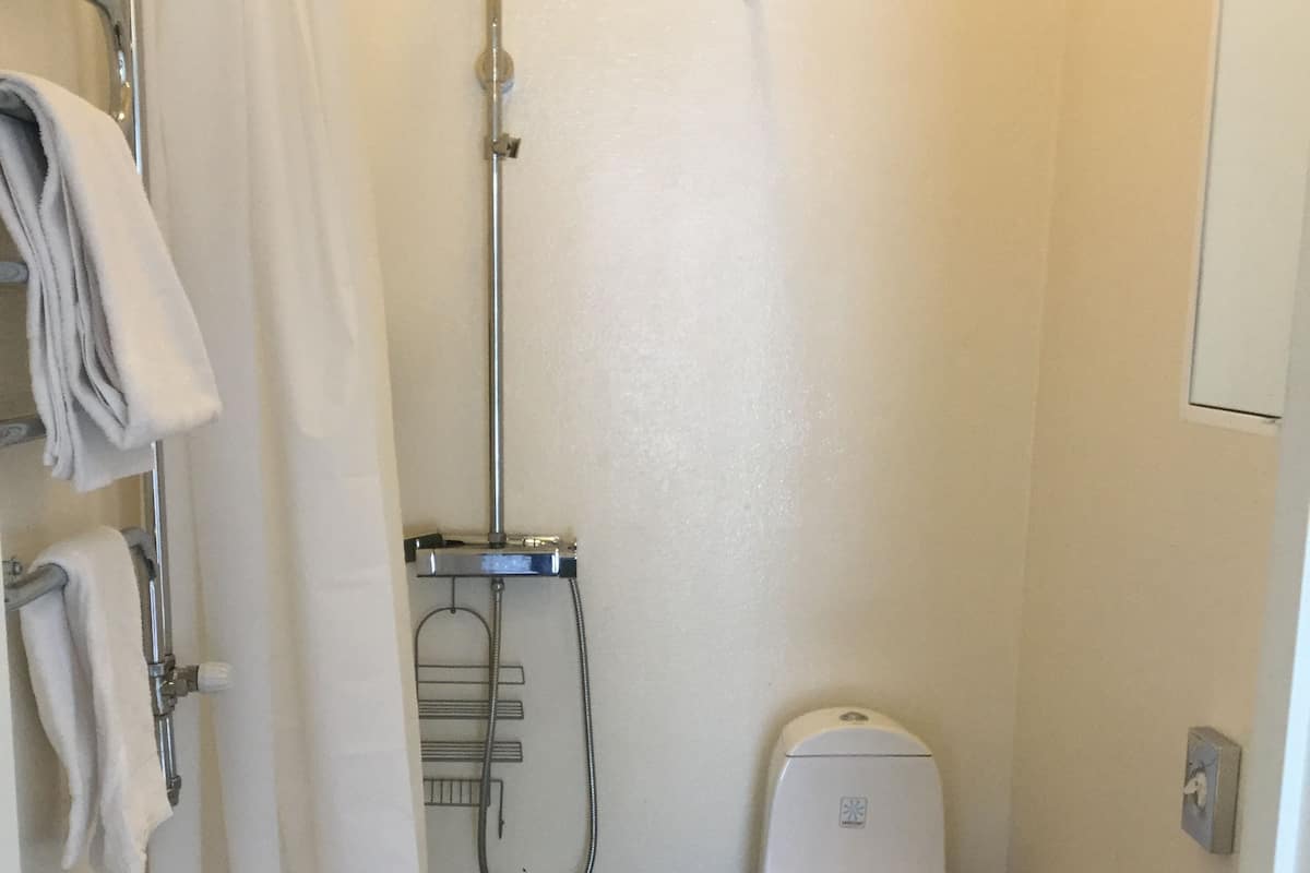 Ein kleines, kompaktes Badezimmer mit Dusche, Toilette und Waschbecken.