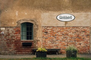 Un edificio de ladrillo con un letrero que dice 'Gärdsshotell' y una ventana con marco verde.