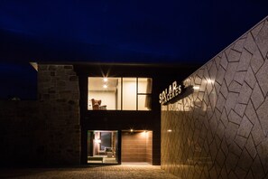 A modern building with a stone facade and a glass entrance. - Solar Dos Cáceres (Fornos de Algodres)