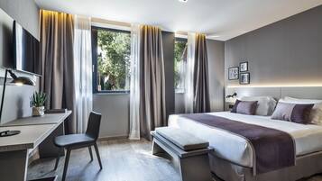 Sengetøy av topp kvalitet, dundyner, minibar og safe på rommet