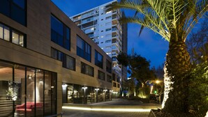 A modern building with large windows and a well-lit entrance area. - Hotel Upper Diagonal (Barcelona)