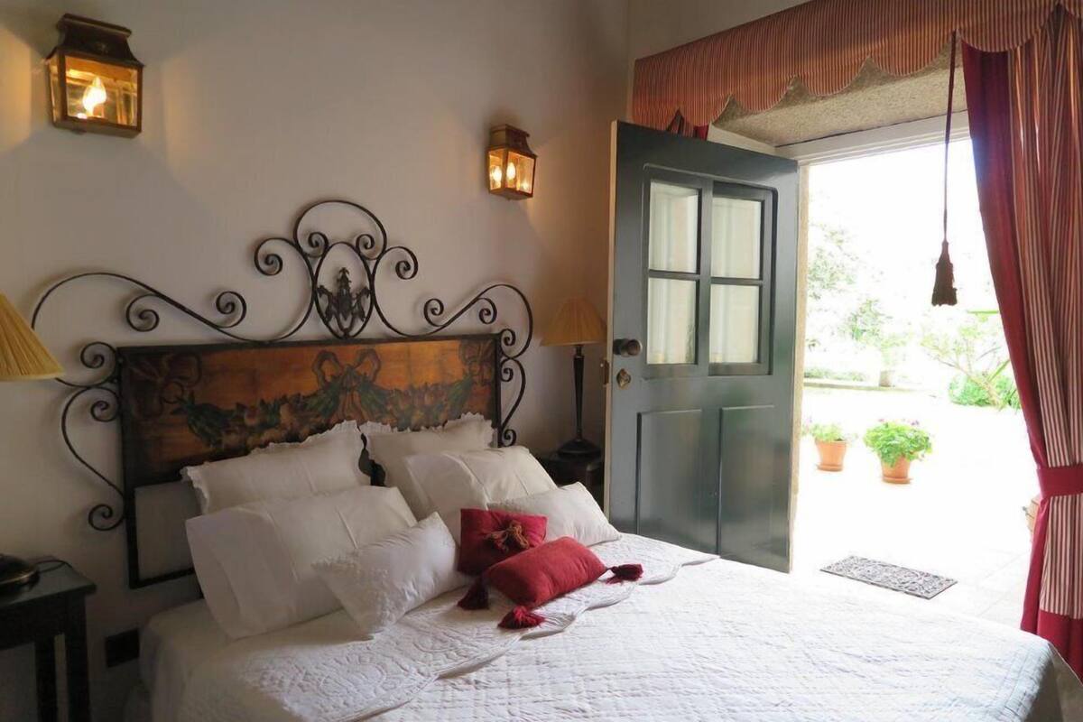 A bedroom with a bed, a door, and two wall-mounted lights.