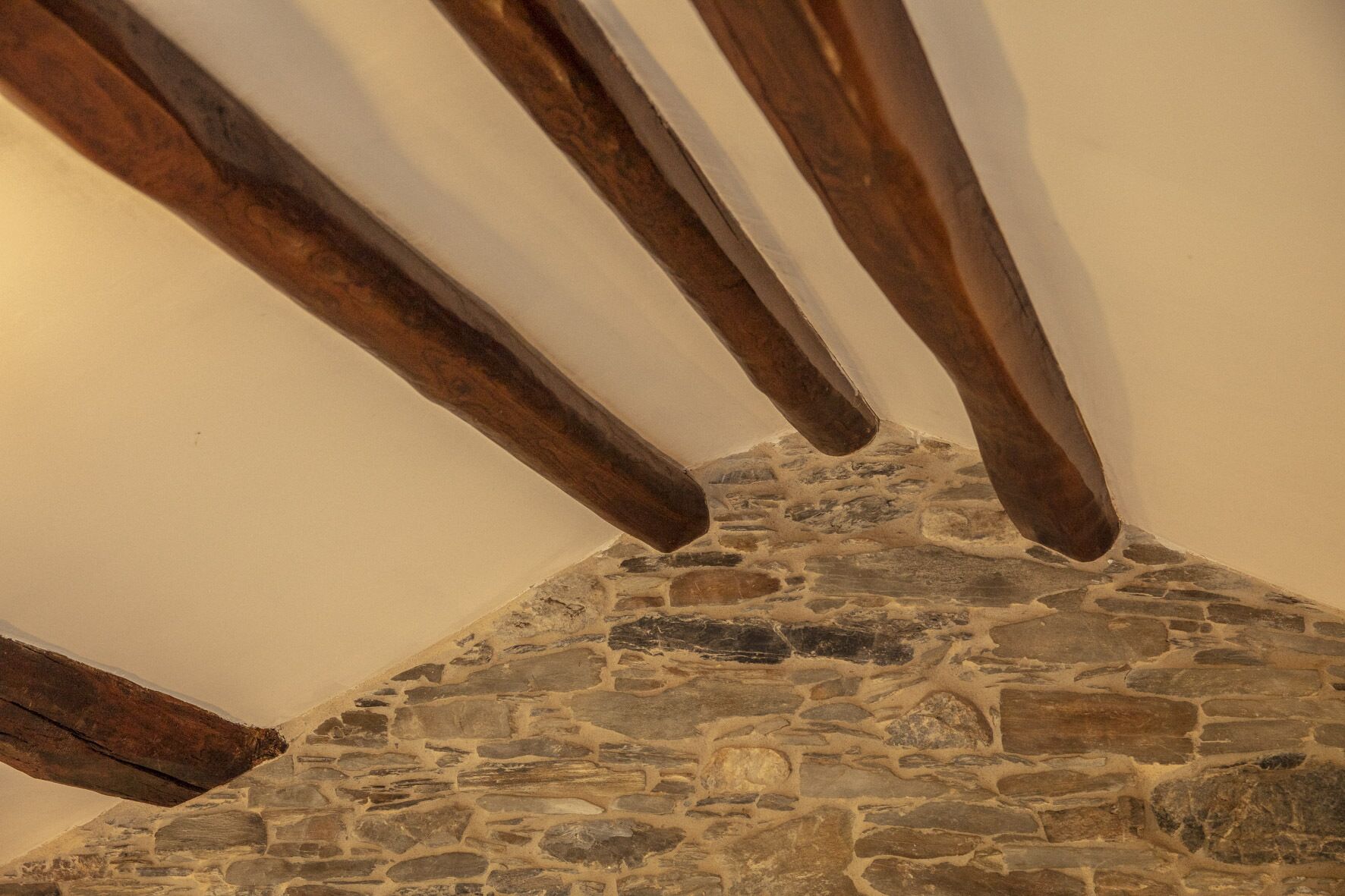 A stone ceiling with exposed wooden beams.
