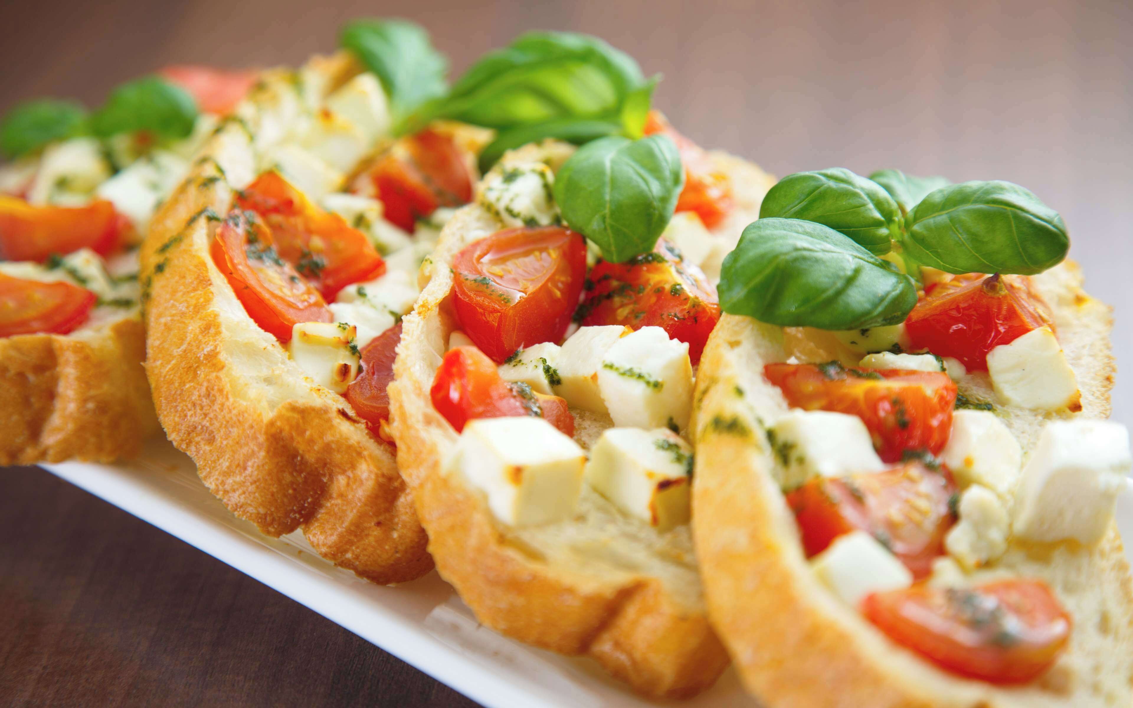 A close-up of a dish with bread, tomatoes, and cheese.