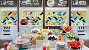 Een buffet met diverse gerechten en een bord waarop staat: 'LACHEN IS DE BESTE OEFENING'.