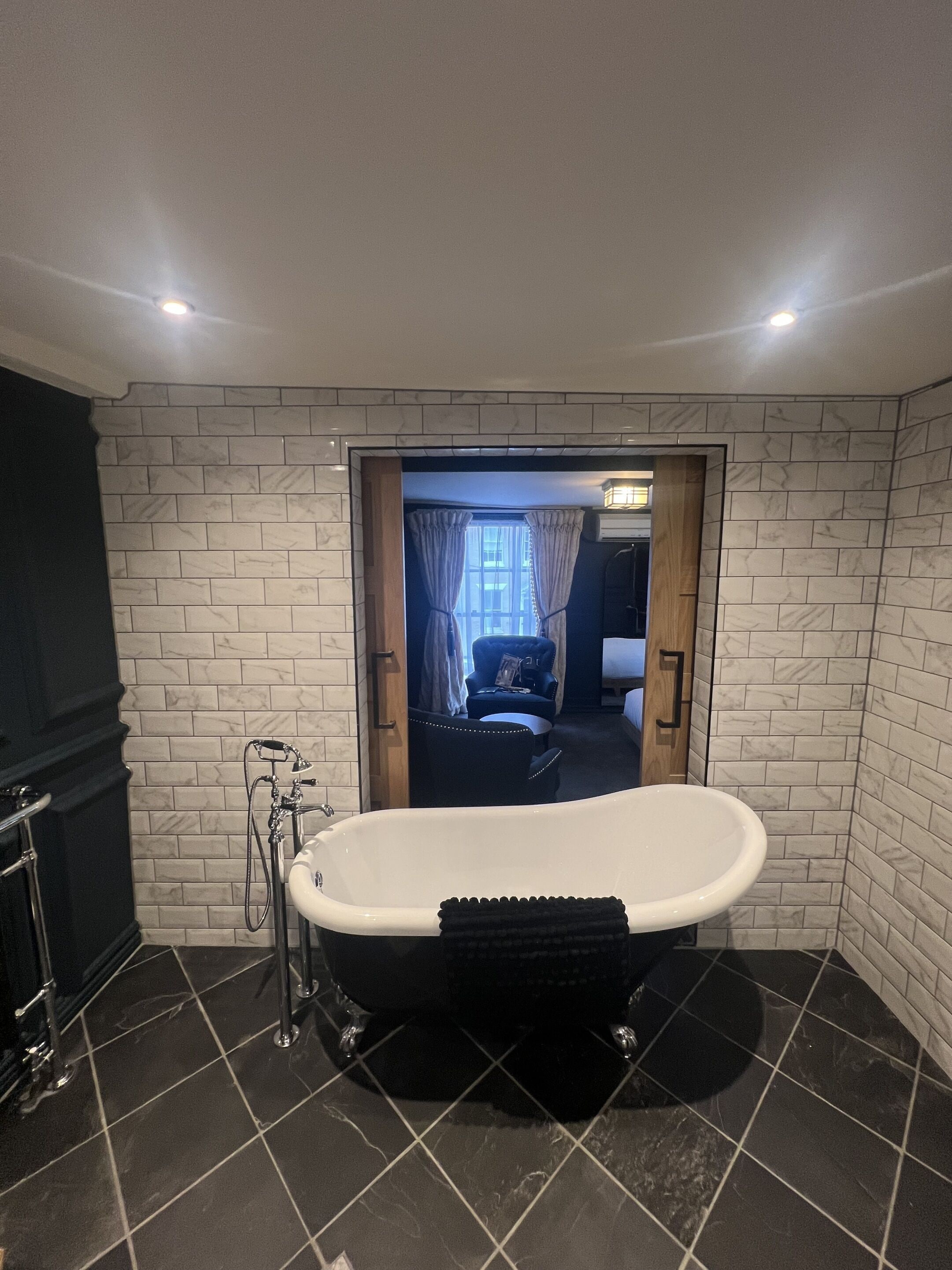 A bathroom with a freestanding bathtub, a shower, and a tiled floor.