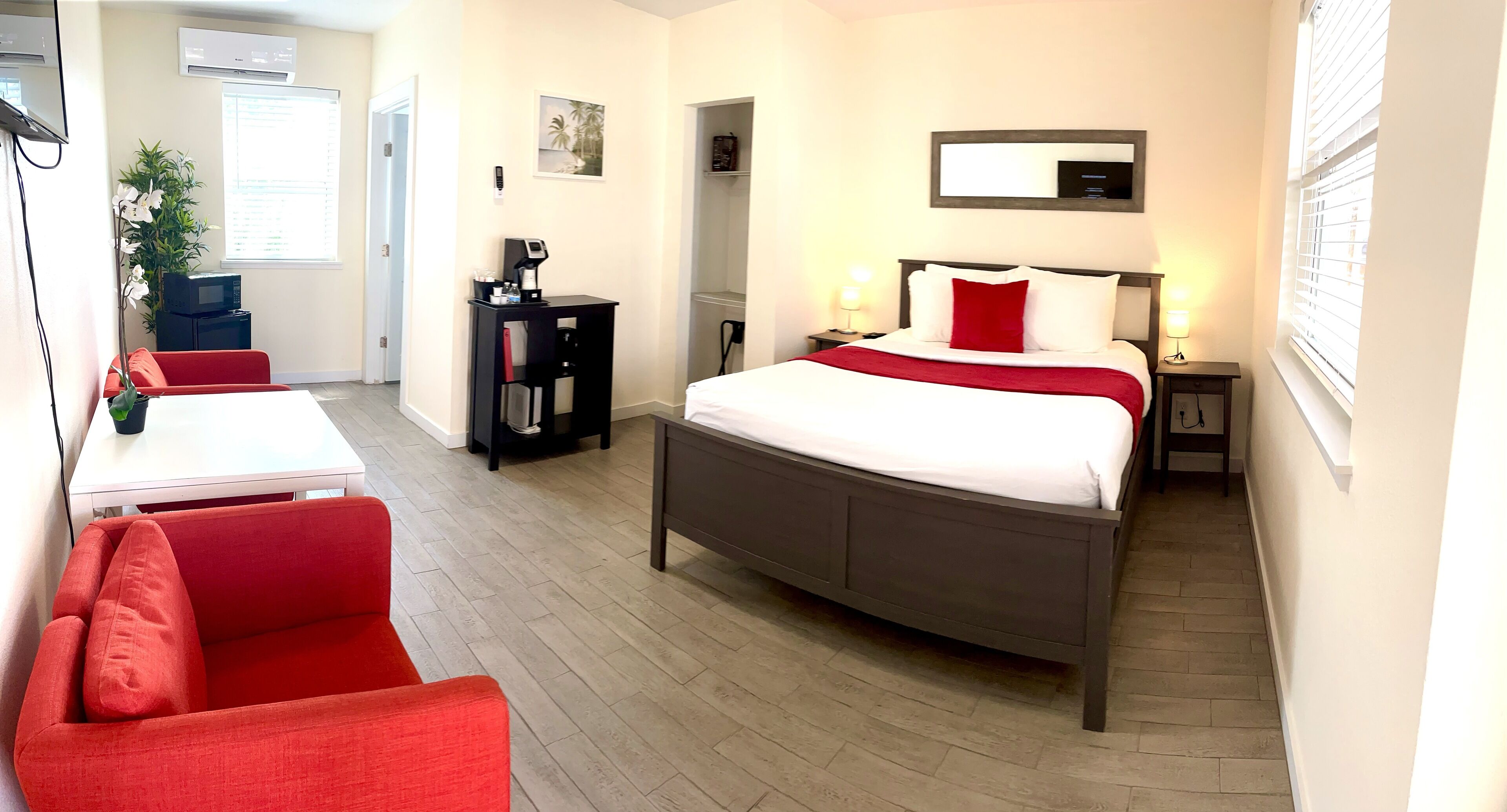 Una habitación de hotel con cama, escritorio, silla y una mesita.